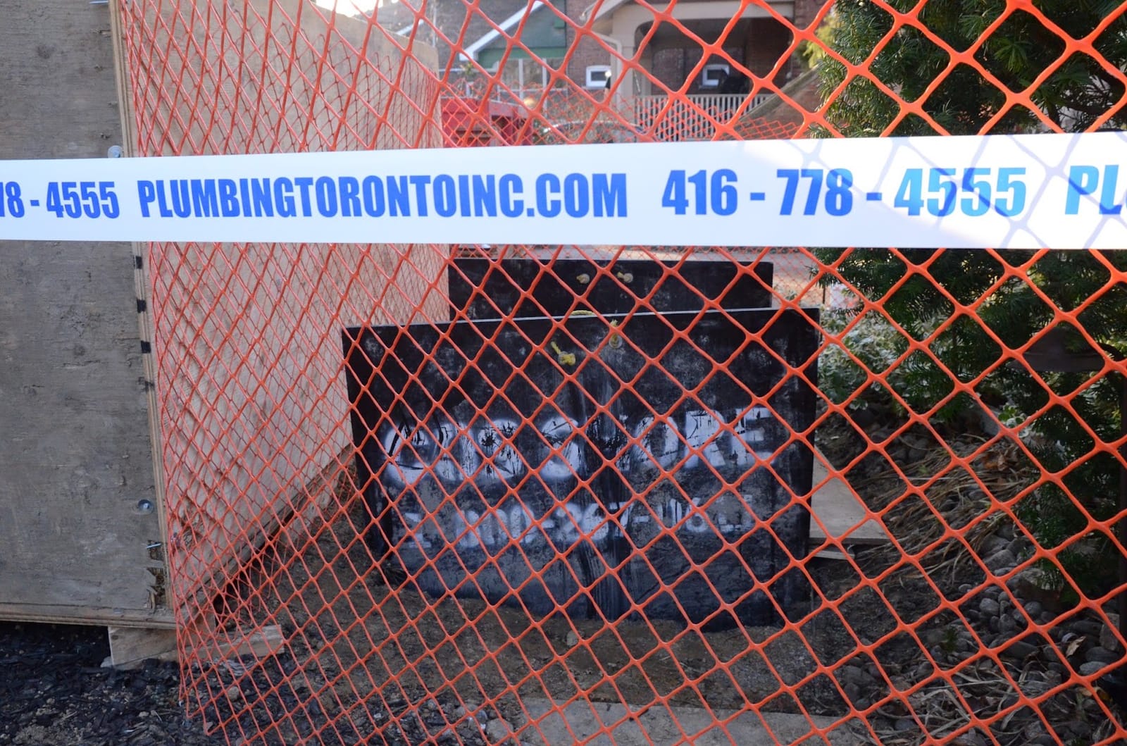 A Waterman- Aquarius Drain excavation job site in Toronto, with the company banner and phone number on the safety fence